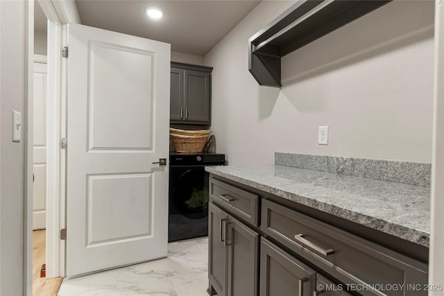 clothes washing area featuring cabinets and washer / clothes dryer