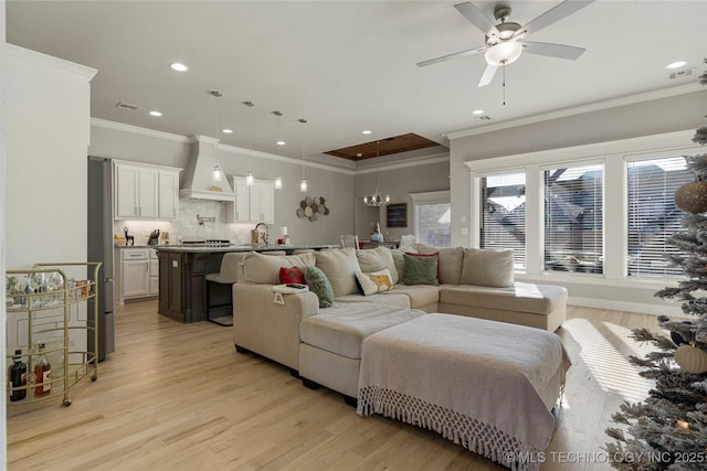 living room featuring ceiling fan, light wood-type flooring, and crown molding