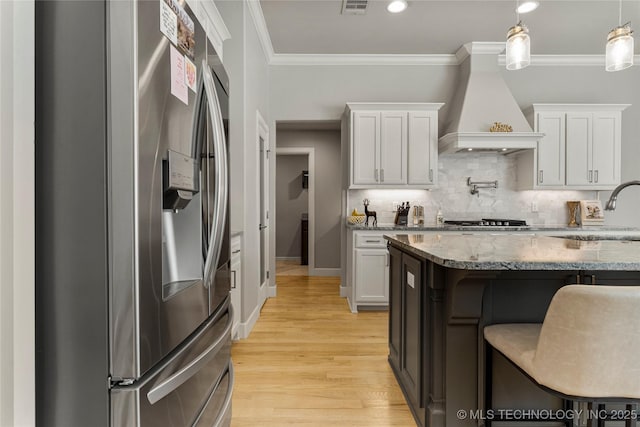 kitchen with custom exhaust hood, white cabinetry, and stainless steel appliances