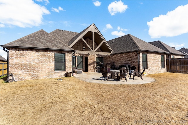 back of house with a patio and a lawn