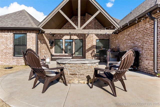 view of patio with grilling area and an outdoor living space with a fire pit