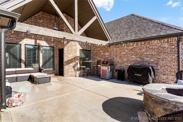 view of patio with outdoor lounge area, a bar, and grilling area