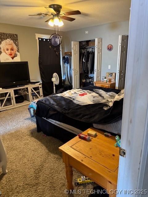 carpeted bedroom featuring ceiling fan and a closet