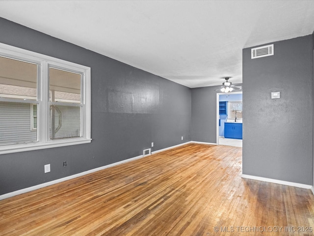 spare room featuring ceiling fan, wood-type flooring, and sink