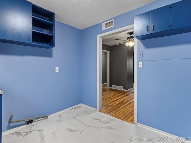 spare room with a textured ceiling and ceiling fan