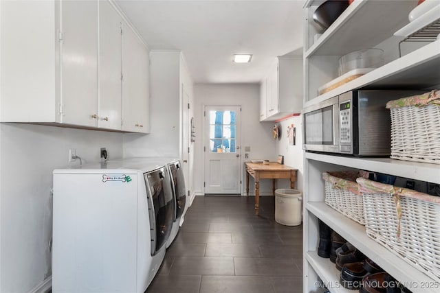 clothes washing area featuring cabinets, dark tile patterned flooring, and independent washer and dryer