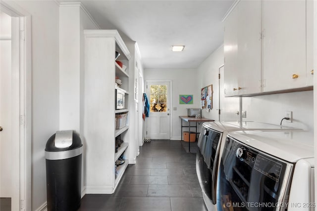 clothes washing area with cabinets and washing machine and clothes dryer