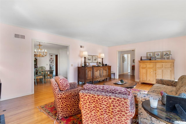 living room featuring a chandelier and light wood-type flooring