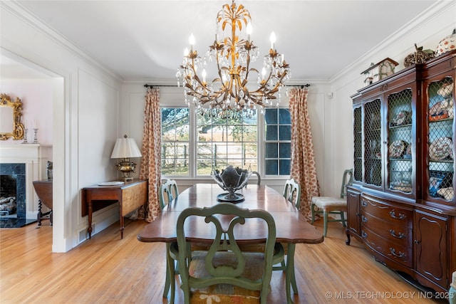 dining space with ornamental molding, a premium fireplace, and light wood-type flooring