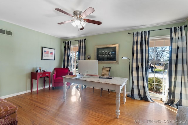 home office with plenty of natural light, ceiling fan, and light wood-type flooring