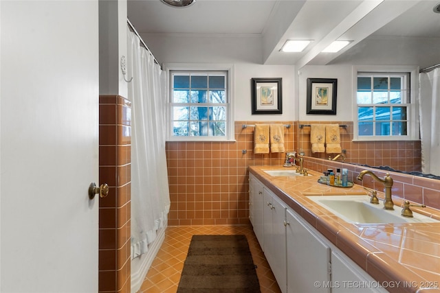 bathroom featuring crown molding, vanity, tile patterned flooring, and tile walls