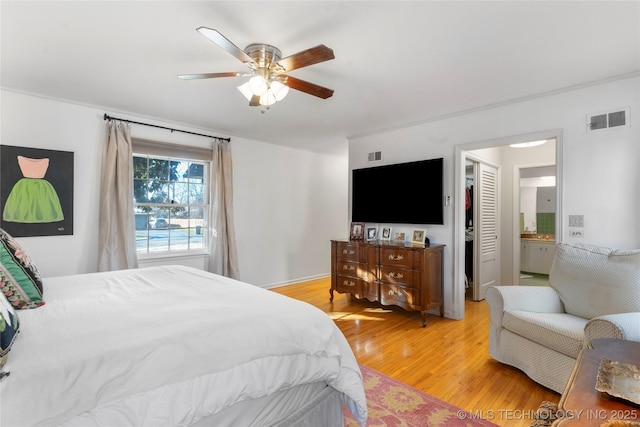 bedroom featuring ceiling fan, ensuite bath, and light hardwood / wood-style flooring