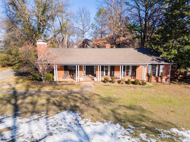 ranch-style home featuring a yard and covered porch