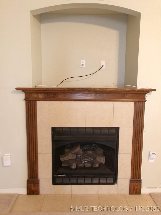 interior details featuring a tile fireplace