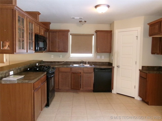 kitchen with sink, light tile patterned floors, and black appliances