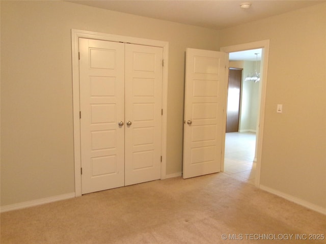 unfurnished bedroom featuring a closet and light carpet