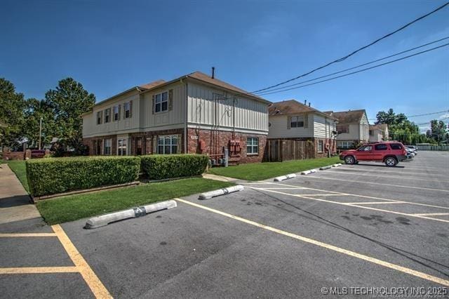 view of parking / parking lot featuring a yard