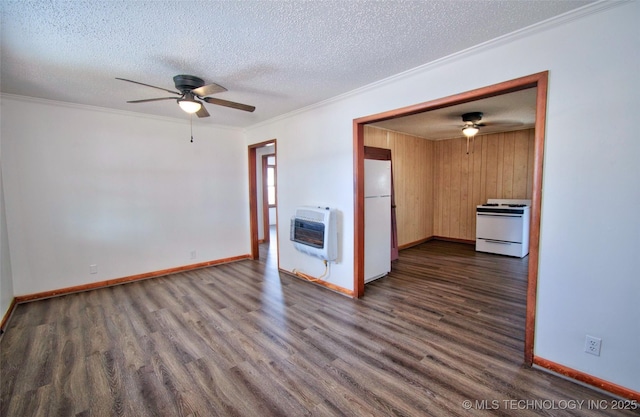 interior space featuring dark hardwood / wood-style flooring, ornamental molding, a textured ceiling, heating unit, and wooden walls