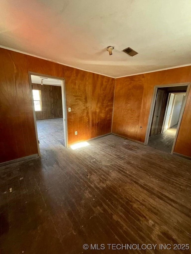 spare room with dark hardwood / wood-style floors and wooden walls