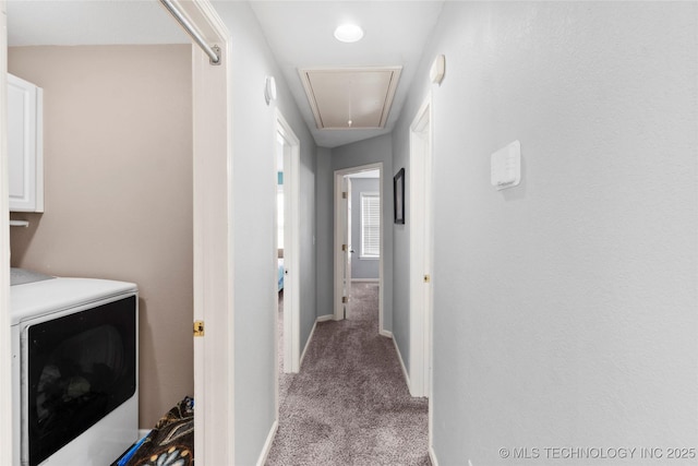 hallway with washer / clothes dryer and light colored carpet