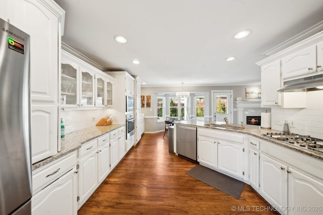 kitchen with sink, white cabinets, light stone counters, and appliances with stainless steel finishes