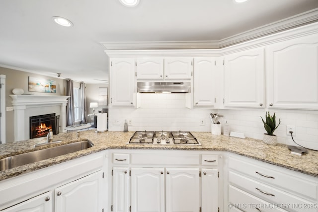 kitchen with sink, stainless steel gas stovetop, white cabinetry, and decorative backsplash