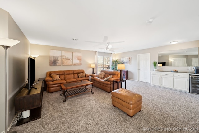 carpeted living room featuring ceiling fan and beverage cooler