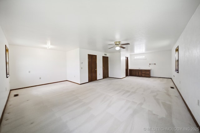 unfurnished room with ceiling fan and light carpet