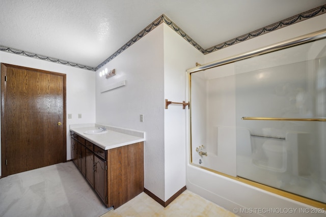 bathroom featuring vanity, a textured ceiling, and shower / bath combination with glass door