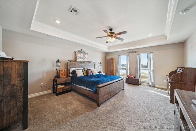 bedroom with ceiling fan, carpet flooring, and a tray ceiling