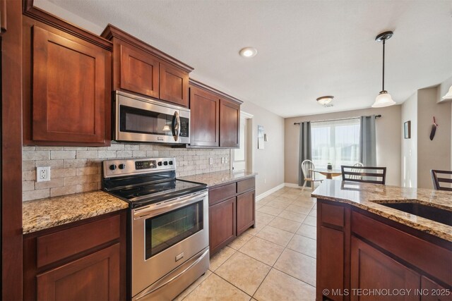 kitchen with stainless steel appliances, light stone counters, light tile patterned floors, backsplash, and hanging light fixtures