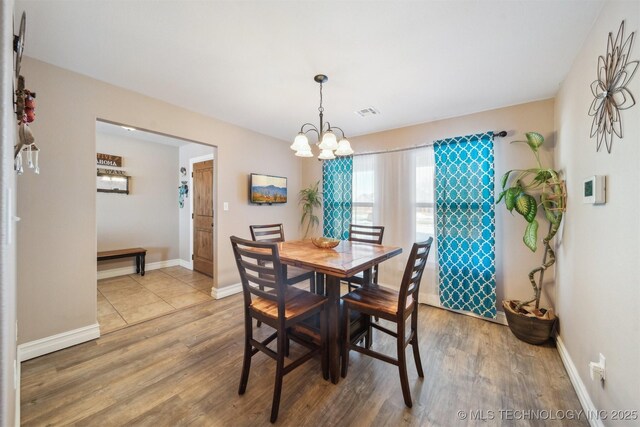 dining area with hardwood / wood-style flooring and a chandelier