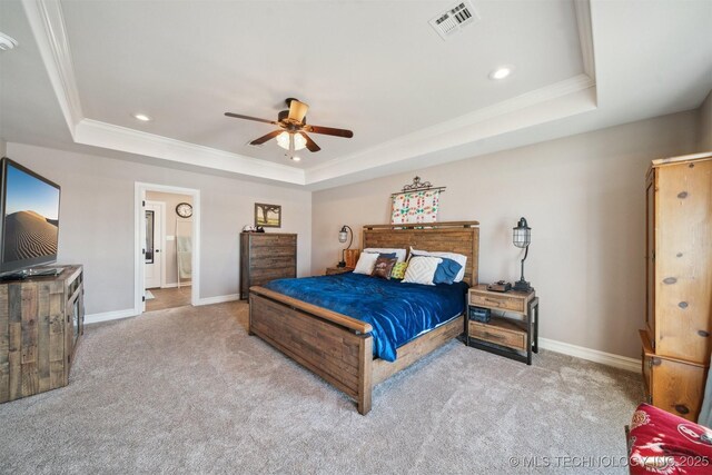 carpeted bedroom with ceiling fan, crown molding, connected bathroom, and a raised ceiling