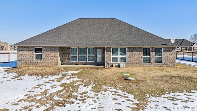 snow covered house featuring a lawn