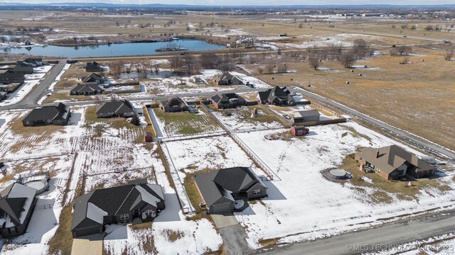 snowy aerial view with a water view