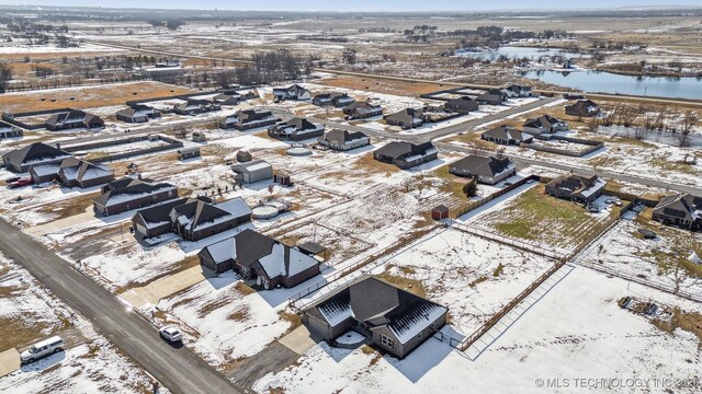 snowy aerial view with a water view