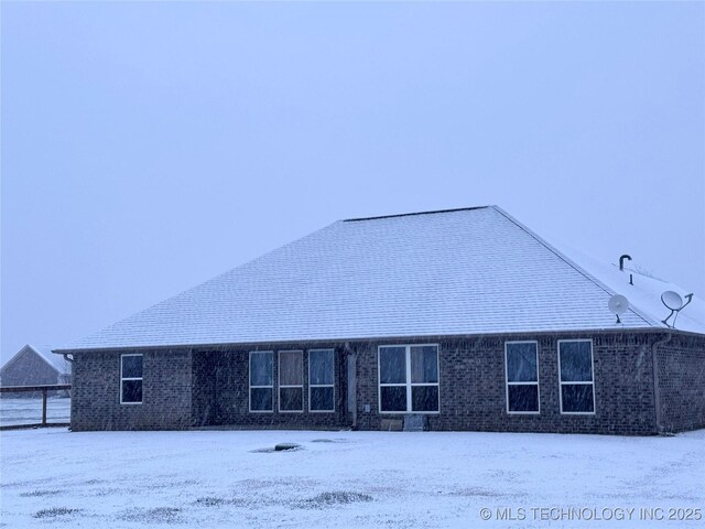 view of snow covered rear of property