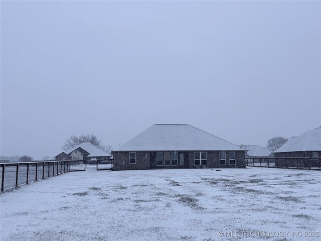 view of snow covered back of property