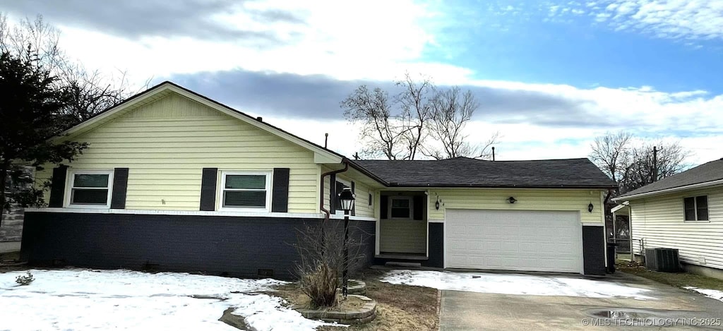 view of front of home with central air condition unit and a garage