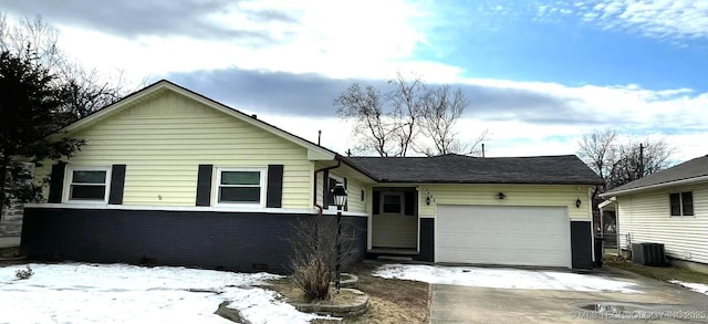 view of front of home with central air condition unit and a garage