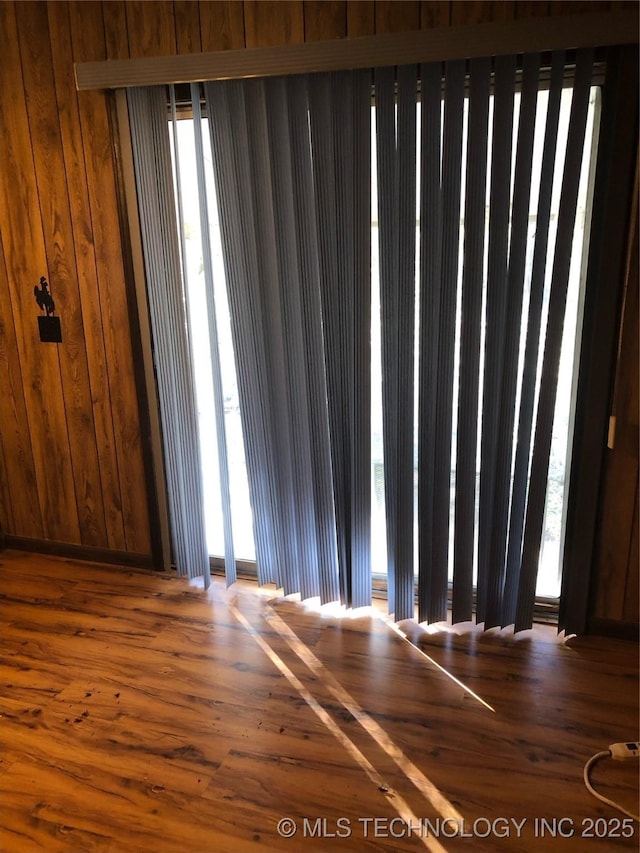 empty room with wooden walls and wood-type flooring