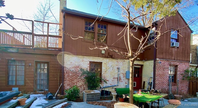 rear view of property featuring central AC unit and cooling unit