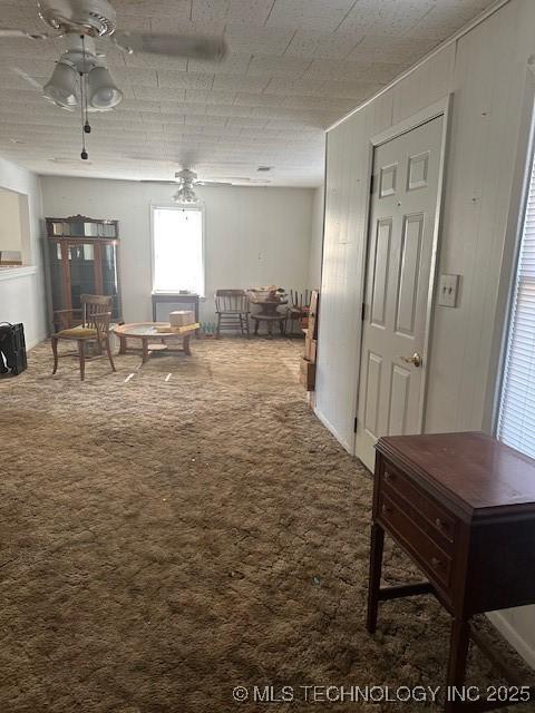 living room with ceiling fan and carpet