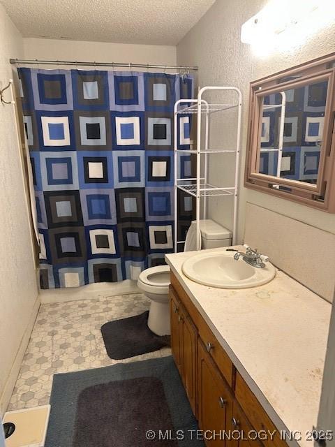 bathroom with toilet, vanity, a shower with curtain, and a textured ceiling