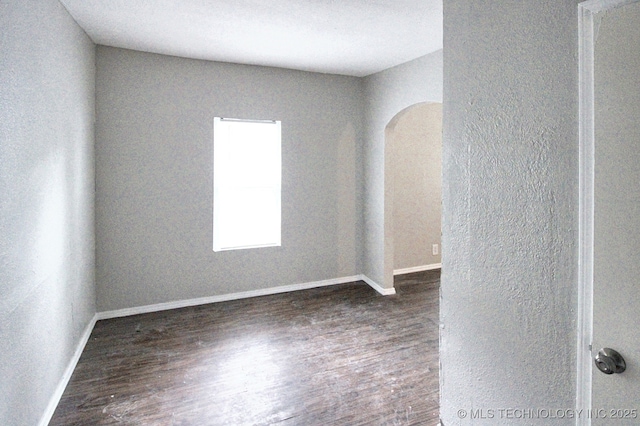 empty room with dark hardwood / wood-style flooring