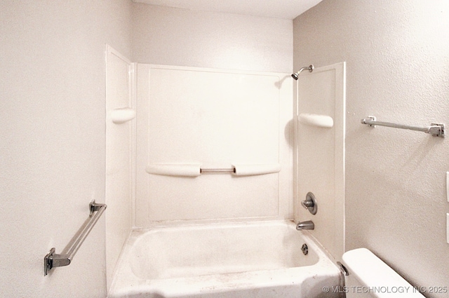 bathroom with toilet and washtub / shower combination