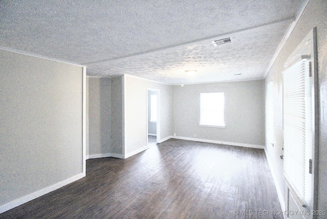 empty room featuring a textured ceiling, ornamental molding, and dark wood-type flooring