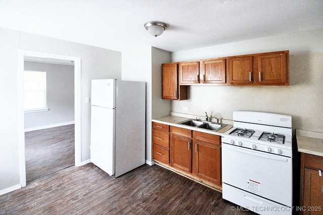 kitchen with sink, dark hardwood / wood-style flooring, and white appliances