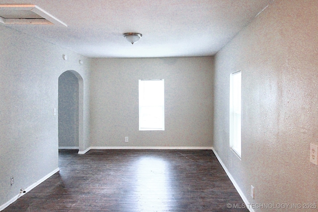 unfurnished room featuring a textured ceiling and dark hardwood / wood-style floors