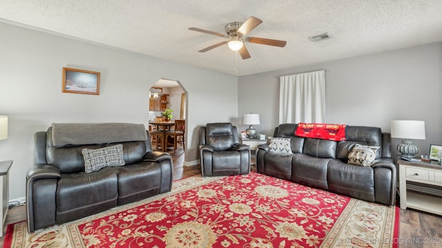 2019 Mckenzie Rd, Pawhuska, OK 74056 - living area featuring arched walkways, ceiling fan, wood finished floors, and a textured ceiling